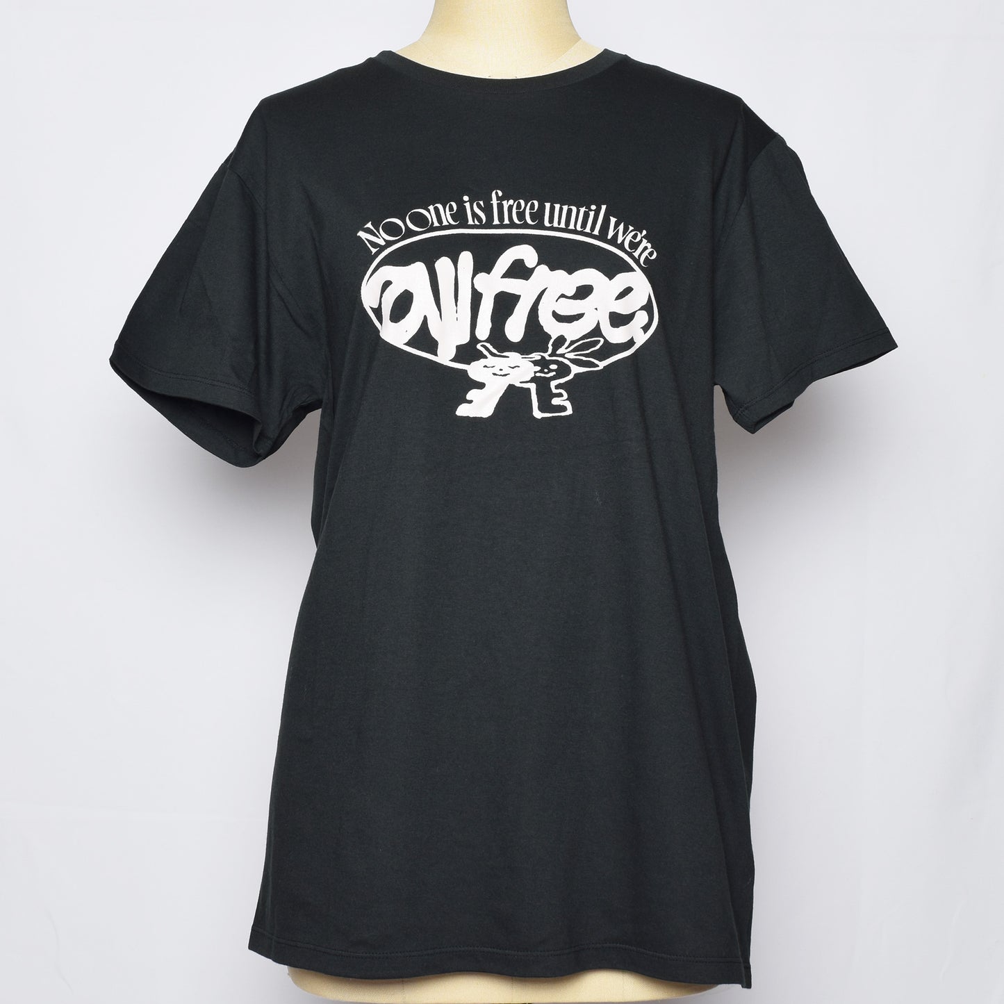ブラックのTシャツにNo one is free until we are all freeの文字と鍵のキャラクターがプリントされている