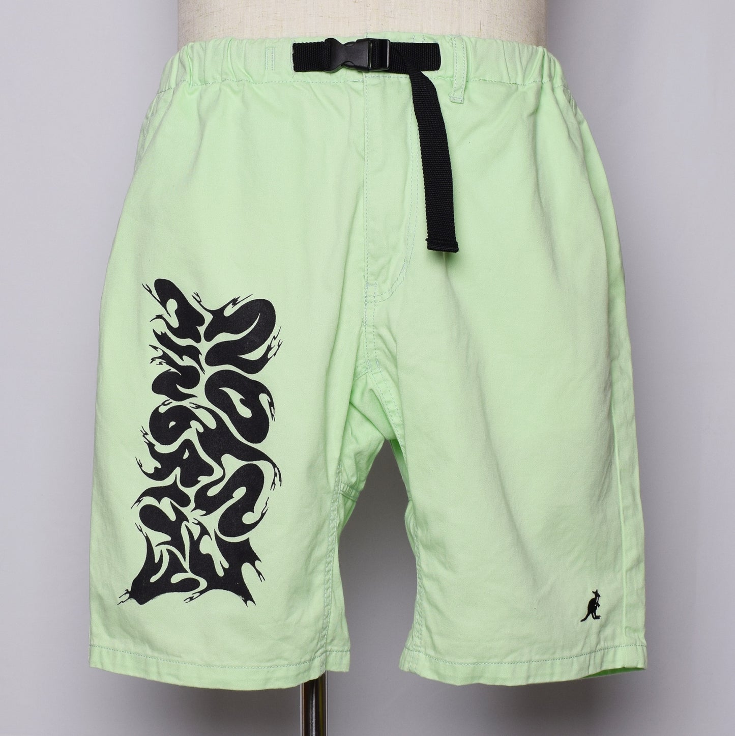 ライムグリーンのハーフパンツにグラフィティ風にNoisy Minorityと黒いインクでプリントしてある