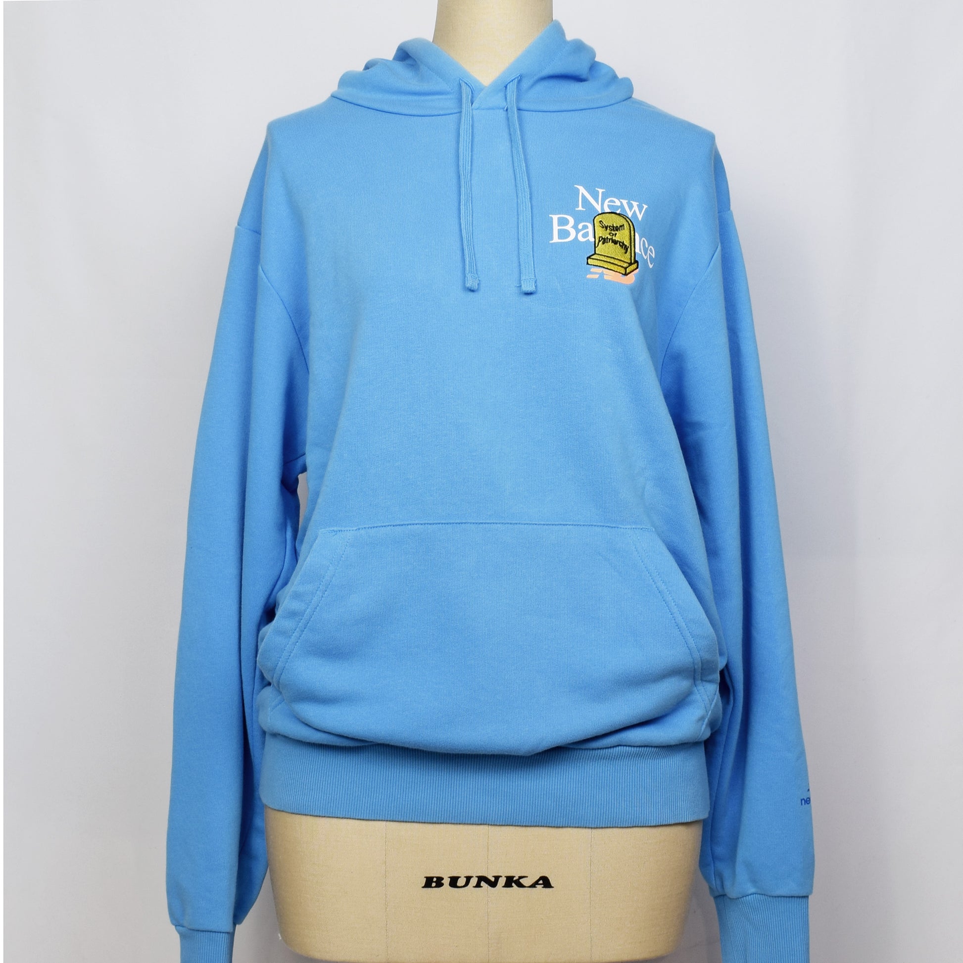 ライトブルーのプルオーバーのパーカーの胸に黄色の家父長制のお墓の刺繍。