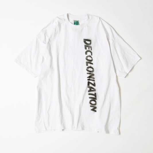 白い大きなTシャツにDECOLONIZATIONの文字が黒いスプレーでペイントされている。素材はコットン100