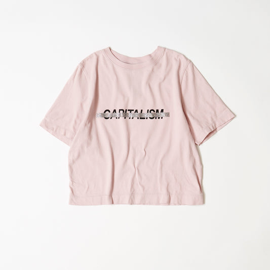 ピンクベージュの半袖TシャツにCAPITALISMの黒いプリントにシルバーのラメで打ち消し線のプリント。表面。コットン１００