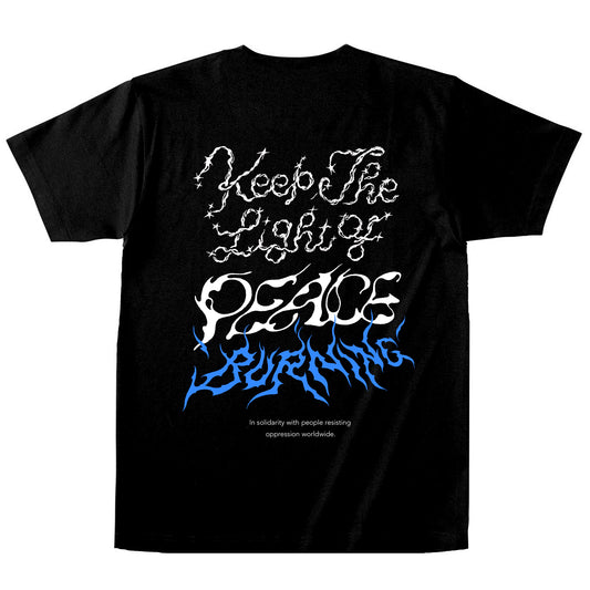 ブラックのボディのTシャツの背面。背中には、Keep The Light of PEACE BURNING、その下にIn solidarity with people resisting oppression worldwideの文字がプリントされている。
"Keep The Light of"の文字はホワイトでキラキラしたトゥインクルがあしらわれ、"PEACE"は風で揺らぐ中でか細く灯されている火のようなイメージ、その下の"BURNING"はブルーで燃え盛る炎のようなイメージ。