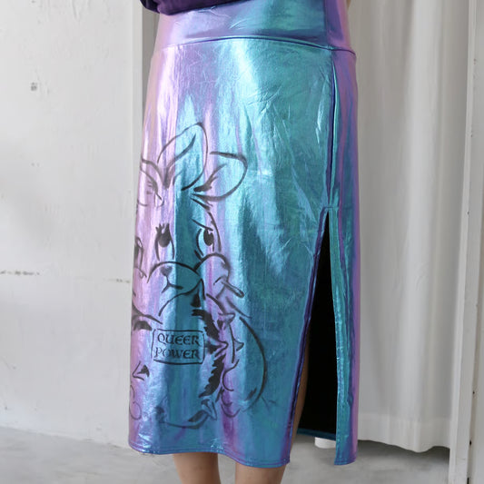 ホログラム色のタイトスカートにQUEER POWERと書かれたハートを抱いたネズミのようなウサギと、DECOLONIZATIONの文字が黒でプリントされている。