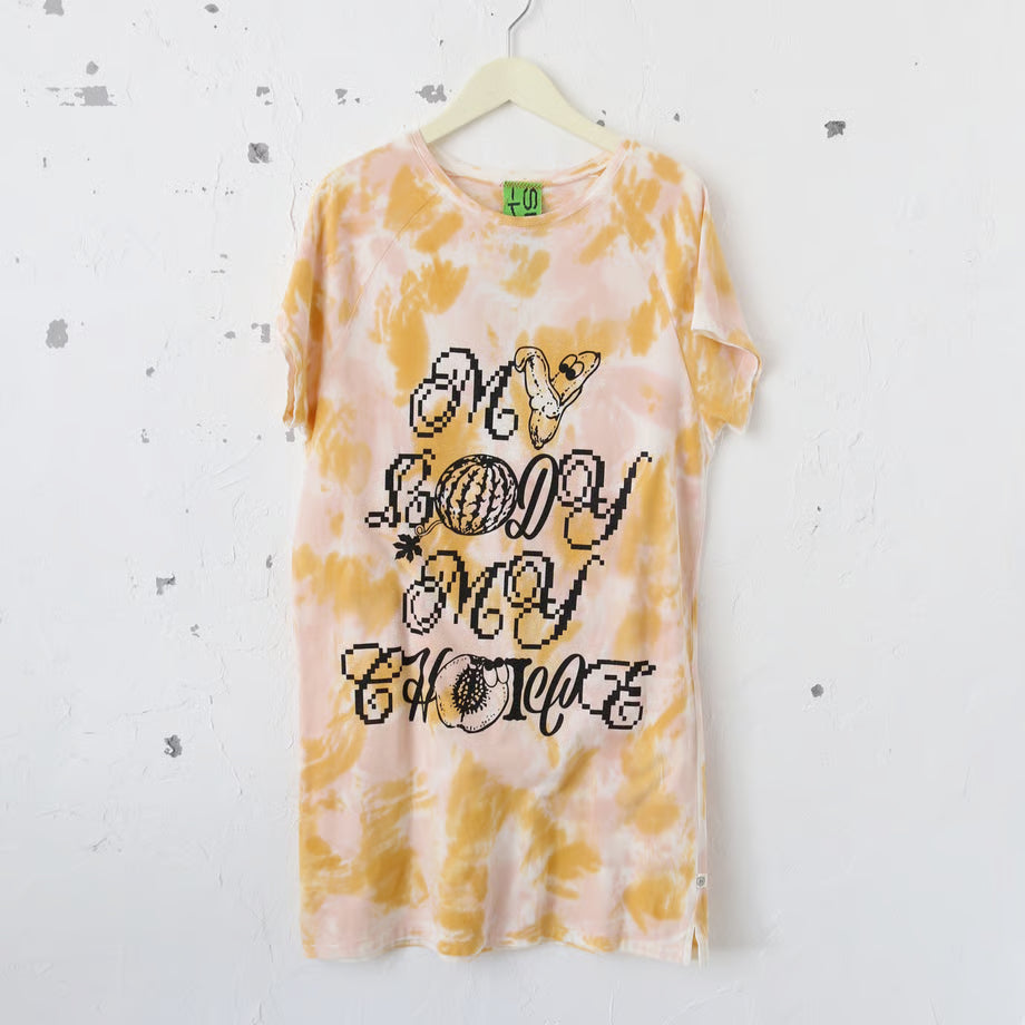 黄色のタイダイ柄の丈長めのTシャツにMY BODY MY CHOICEとバナナとスイカとプラムのグラフィックが印刷されている。