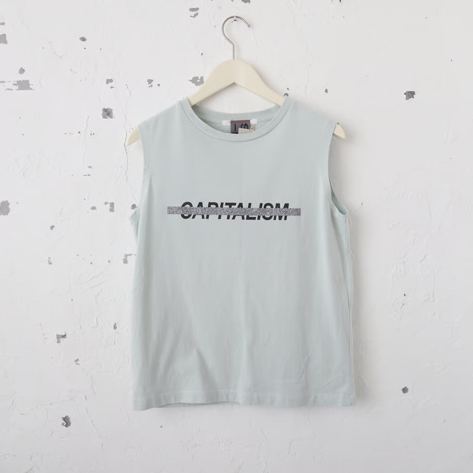くすみミント色のタンクトップにCapitalismの文字とそれを打ち消すようにシルバーのラメのキラキラでプリントされている。