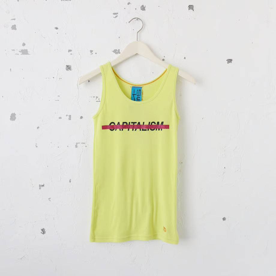 ネオンイエローのタンクトップにCapitalismの文字とそれを打ち消すようにピンクのラメのキラキラでプリントされている。