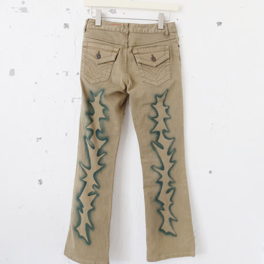 薄いブラウンのデニムパンツに稲妻のようなスプレーペイントと、黒いプリントでno fasism no racism no sexism no colonialism no war　とプリントされている。