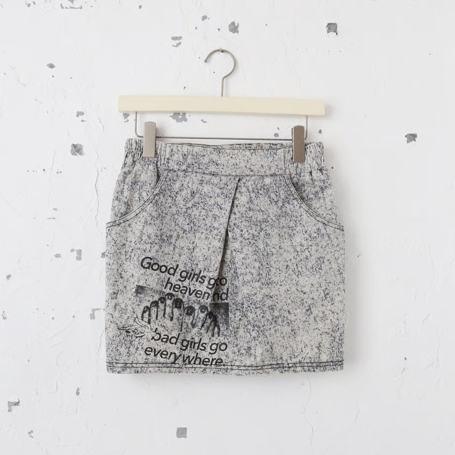 デニム素材のミニスカートにgood girls go to heaven  bad girls go everywhere.の文字と、ペディキュアが塗られた足の写真のグラフィックがプリントされている。