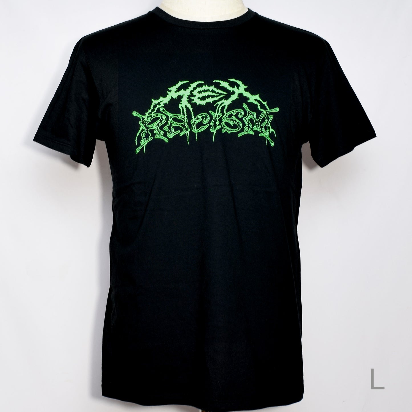 黒のTシャツにメタル風ロゴでHEX RACISM と蛍光グリーンでプリントされている。後ろは祝共生の文字と悪魔、魔女、髭の長い男性の魔女が笑顔でダンスしているイラストがグレーでプリントされている。