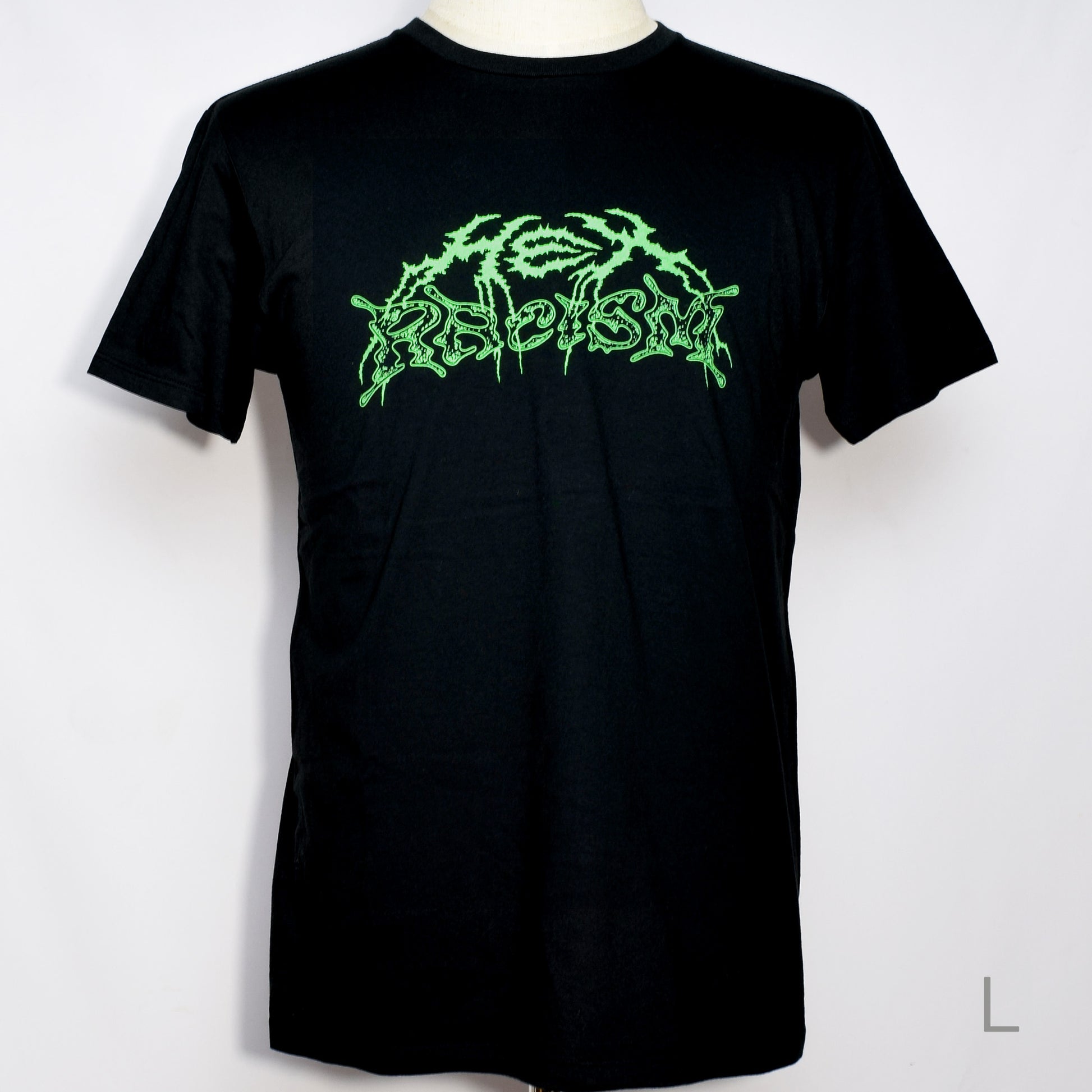 黒のTシャツにメタル風ロゴでHEX RACISM と蛍光グリーンでプリントされている。後ろは祝共生の文字と悪魔、魔女、髭の長い男性の魔女が笑顔でダンスしているイラストがグレーでプリントされている。