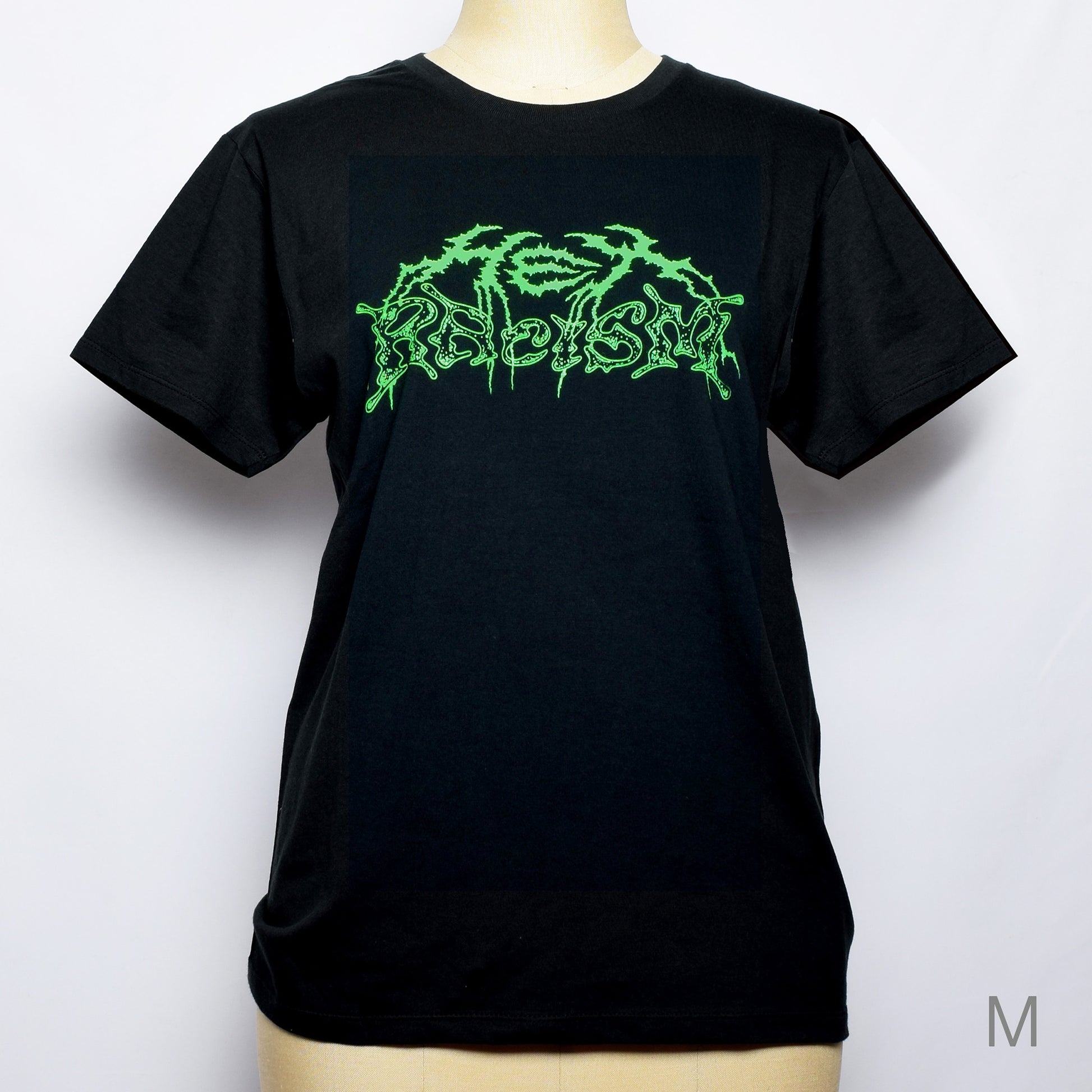 黒のTシャツにメタル風ロゴでHEX RACISM と蛍光グリーンでプリントされている。後ろは祝共生の文字と悪魔、魔女、髭の長い男性の魔女が笑顔でダンスしているイラストがグレーでプリントされている。