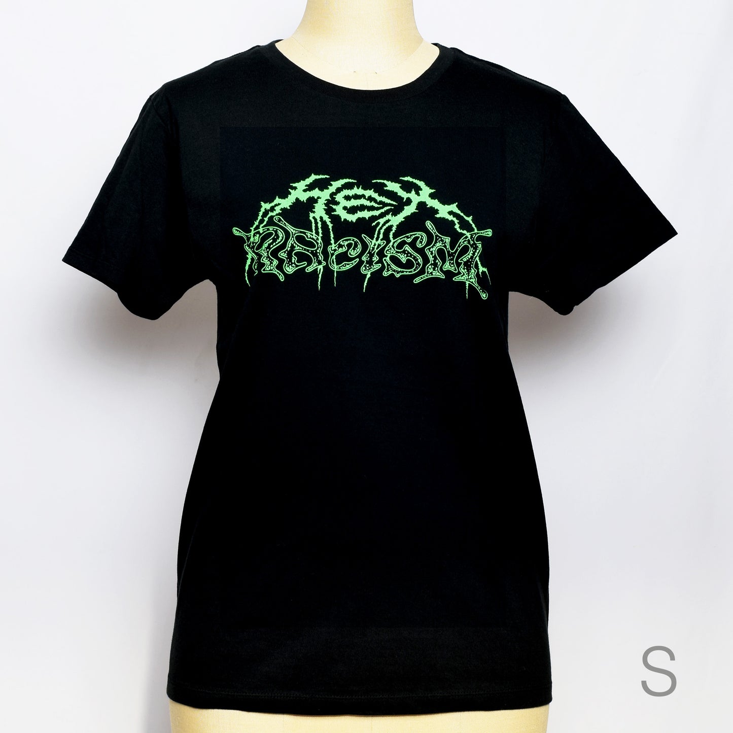 黒のTシャツにメタル風ロゴでHEX RACISM と蛍光グリーンでプリントされている。後ろは祝共生の文字と悪魔、魔女、髭の長い男性の魔女が笑顔でダンスしているイラストがグレーでプリントされている。