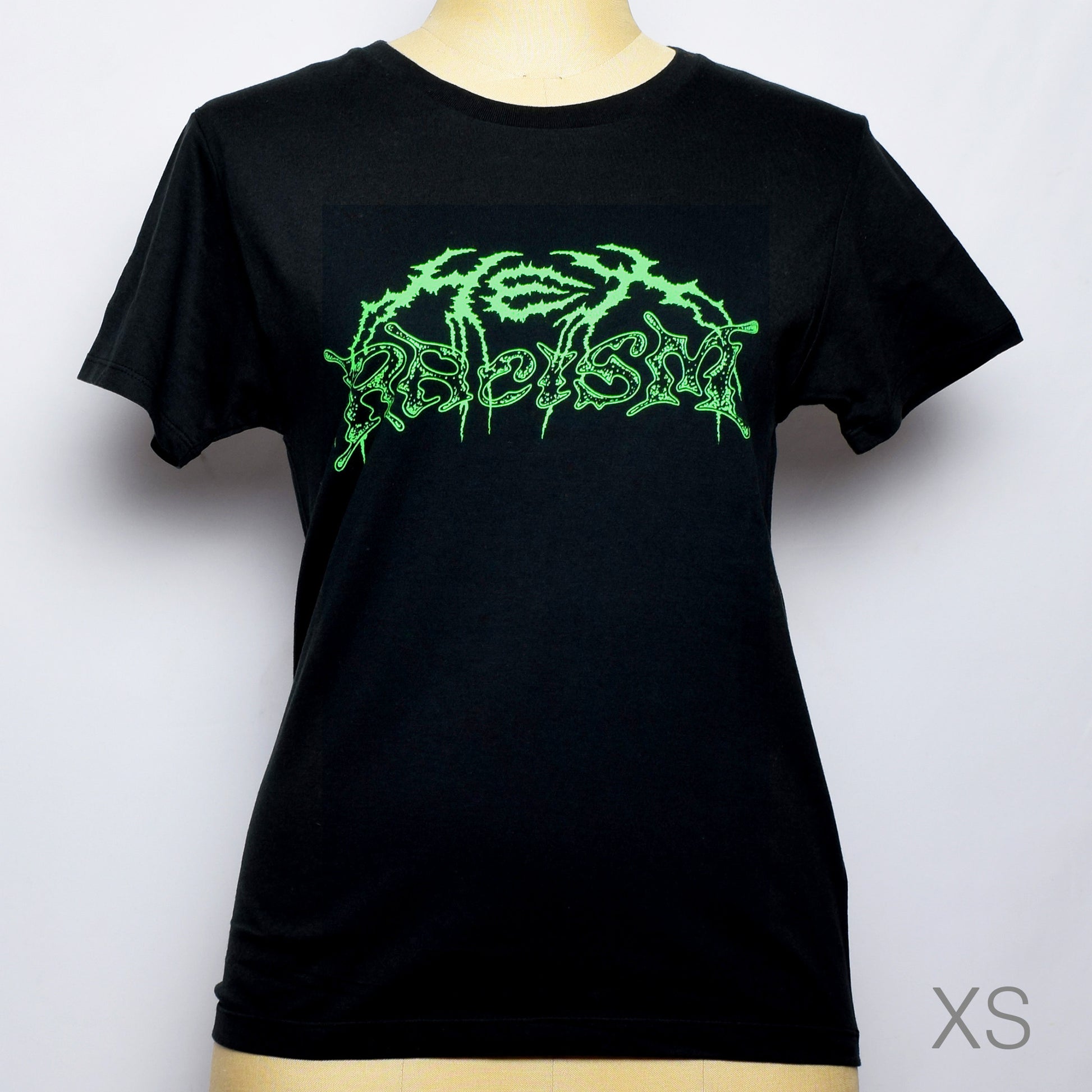 黒のTシャツにメタル風ロゴでHEX RACISM と蛍光グリーンでプリントされている。後ろは祝共生の文字と悪魔、魔女、髭の長い男性の魔女が笑顔でダンスしているイラストがグレーでプリントされている。